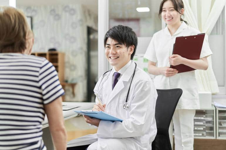 A male Asian doctor examines a patient