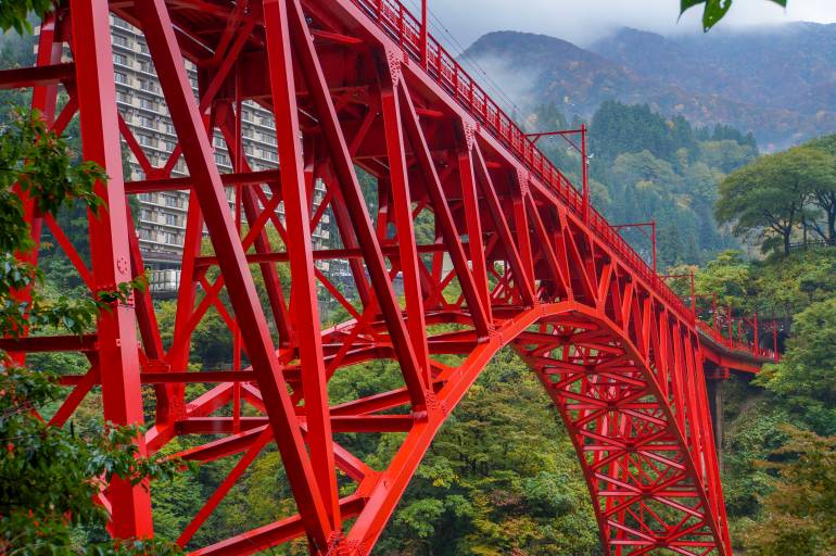 Toyama Prefecture's Kurobe Gorge Railway and the trolley train that crosses the Yamahiko Bridge and the autumn leaves