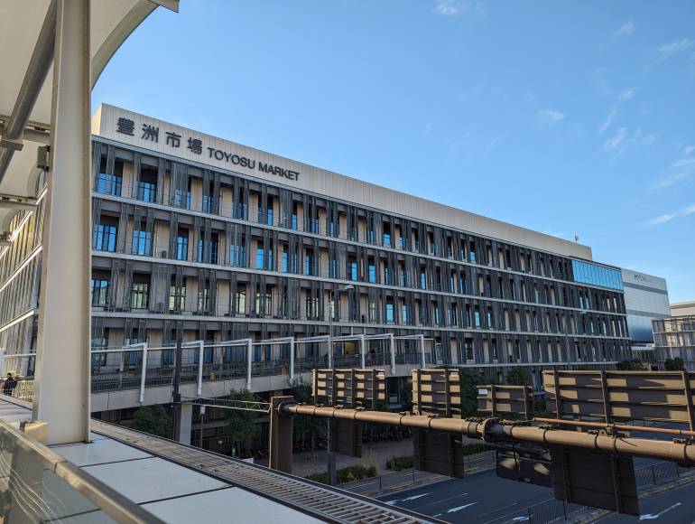 The exterior of a large building with Toyosu Fish Market written on it.